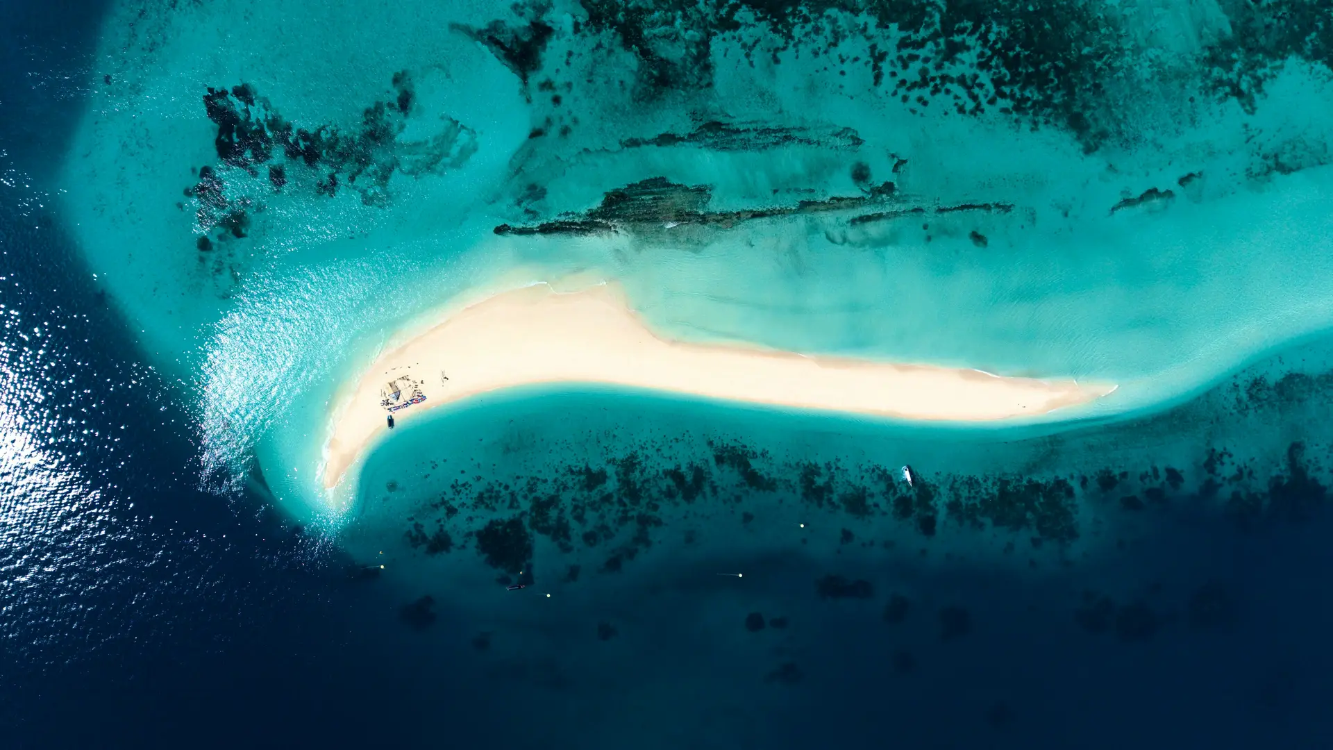 A sandbar surrounded by turquoise water, seen from above, in Zanzibar